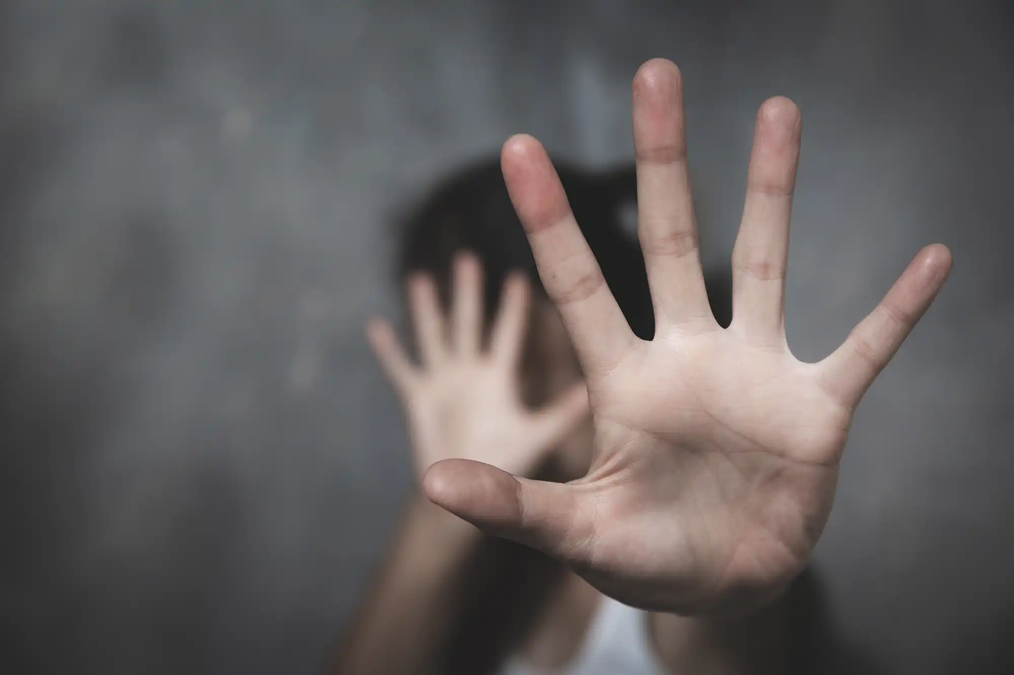 woman's hand in the foreground with her other hand covering her face