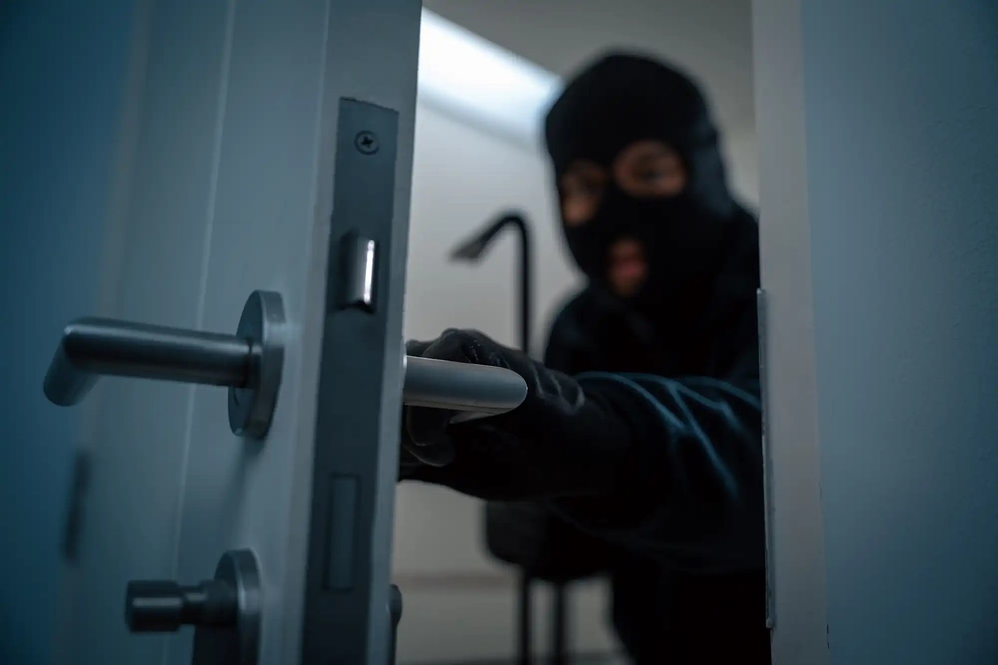 criminal in ski mask opening a door